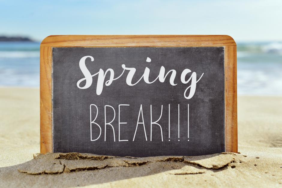 a Spring break sign  sat on a sand beach