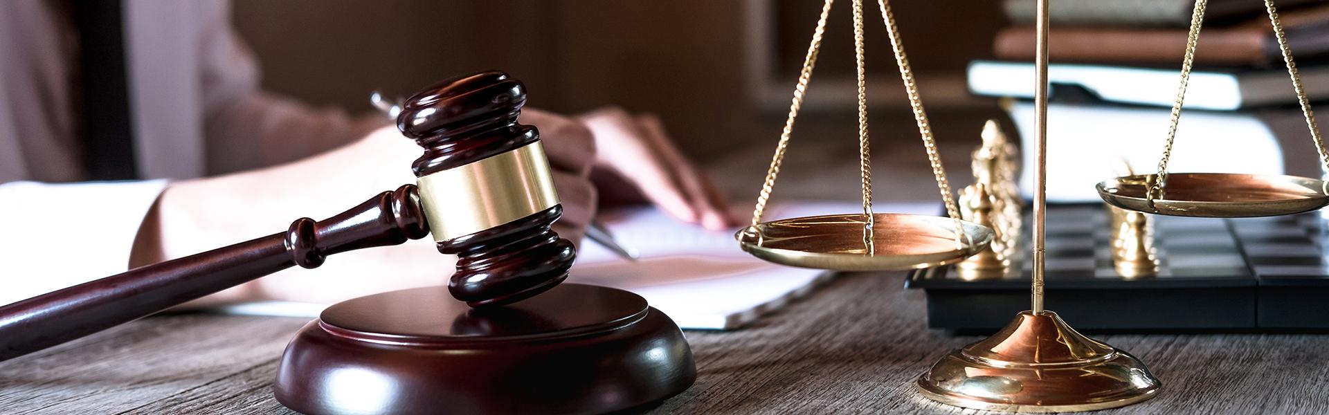 Lawyers working with brass scale on wooden desk in office at background. Law, legal services, advice, Justice concept. 
