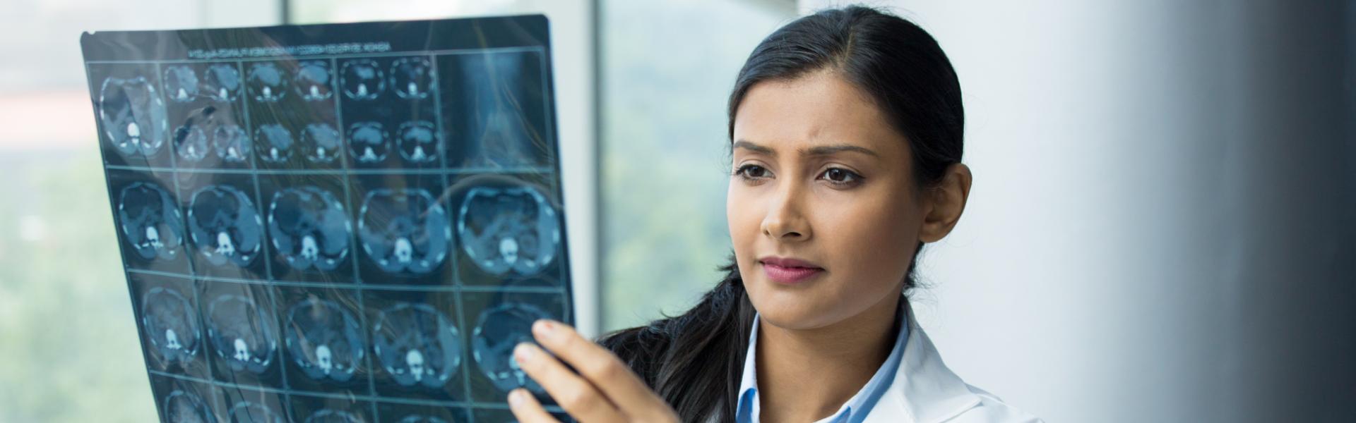 A doctor looking at a set of x-rays.