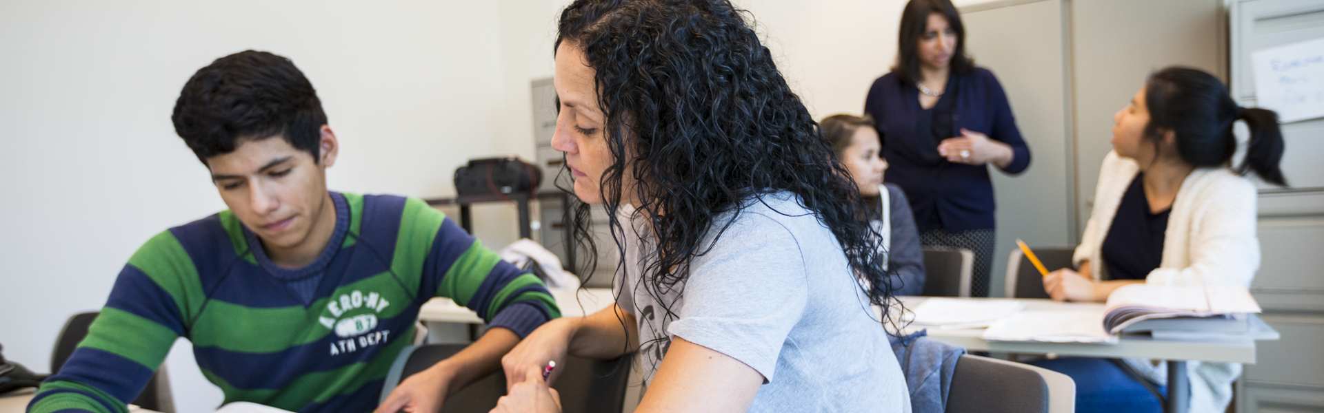 A teacher instructing a make and female student in class.
