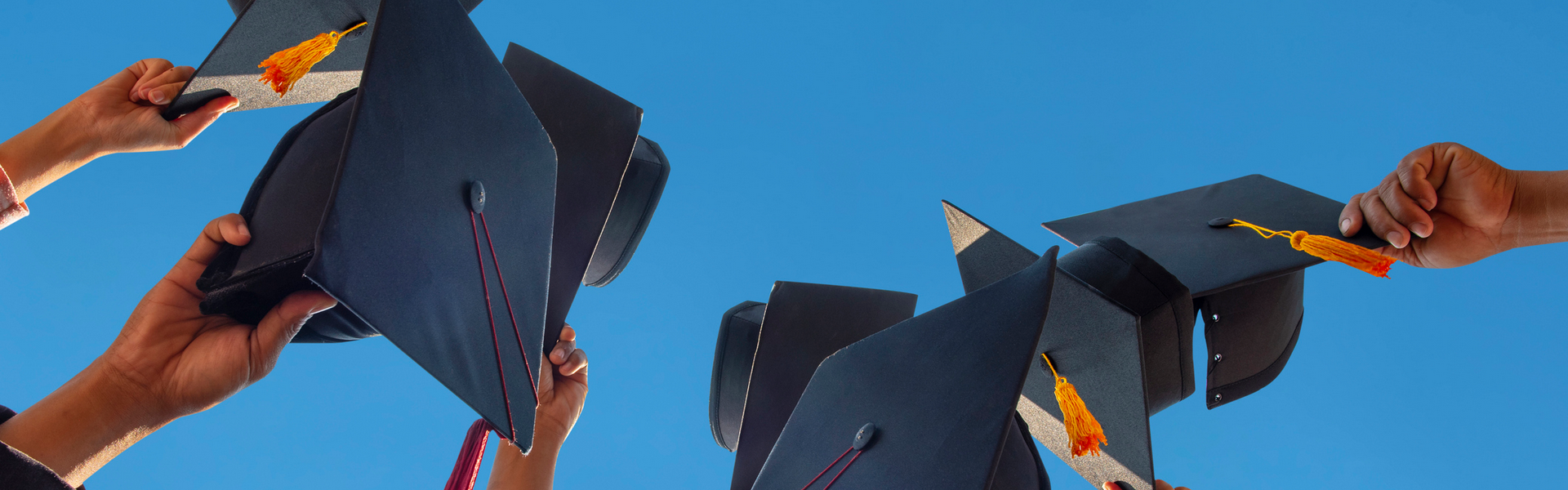 Students holding graduation caps