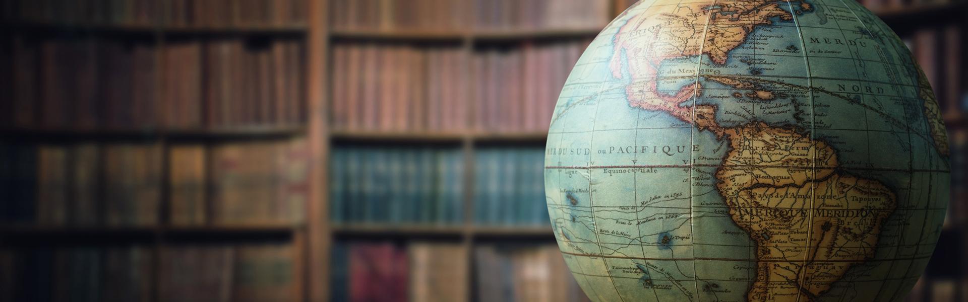 Old globe on bookshelf background. Selective focus. Retro style. Science, education, travel, vintage background.