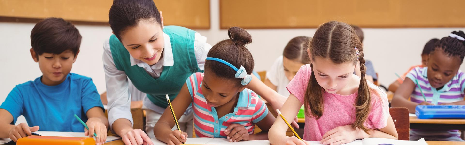 A teacher in class with kids.