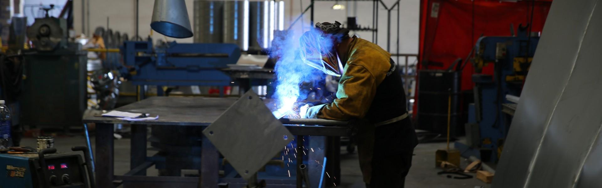 A man spot-welding metal piping.