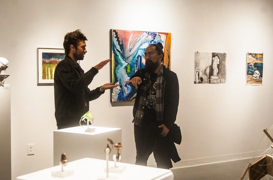 Two people discussing the artwork on display.