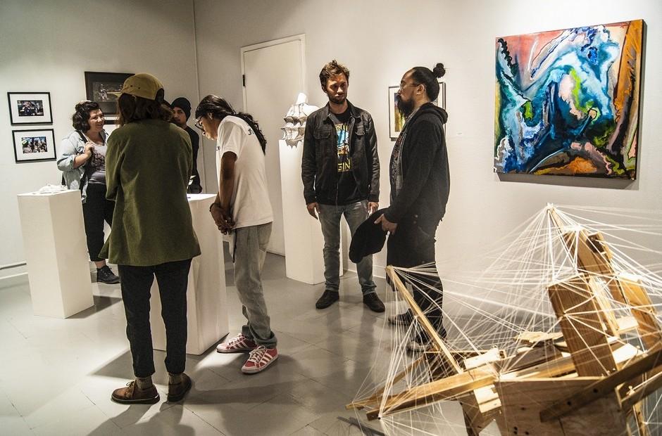 Several people discussing the scupltures on display.