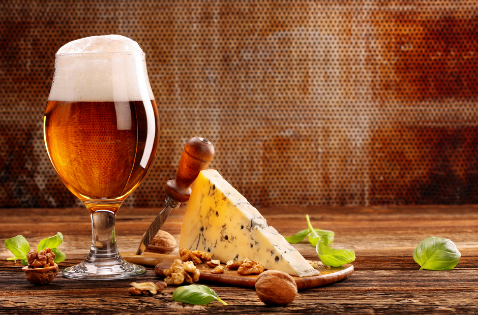 A glass of beer and a block of cheese.