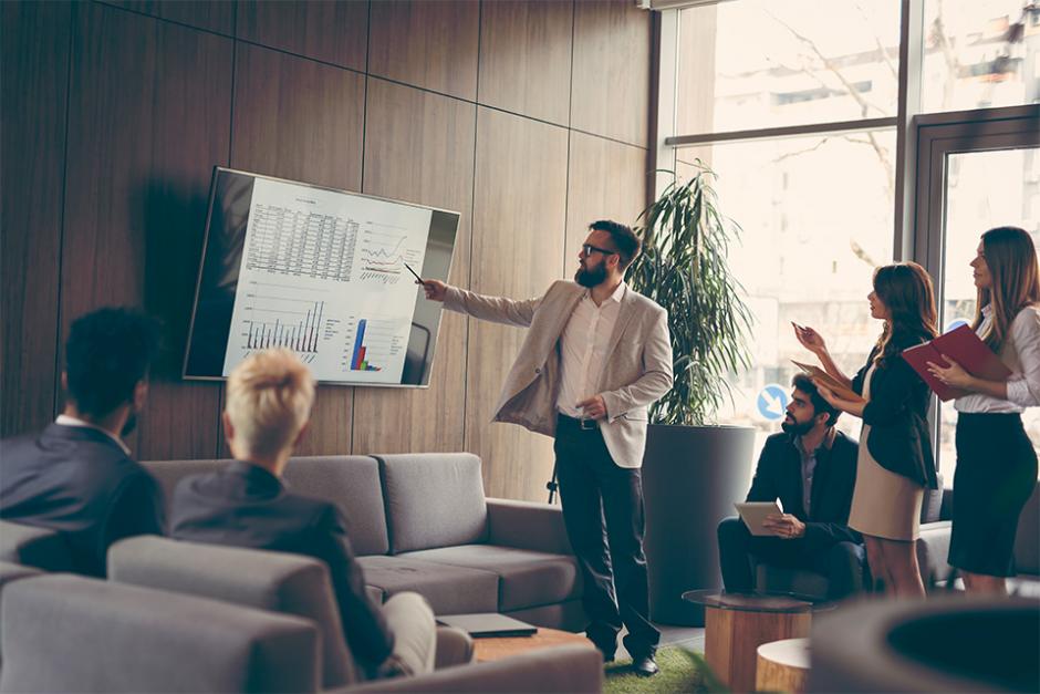 Business colleagues looking at chart to discuss in meeting