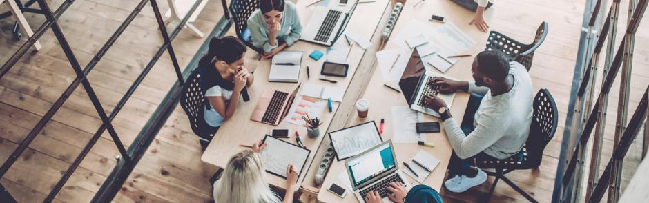 A bird's eye view of people sitting at a conference room table.