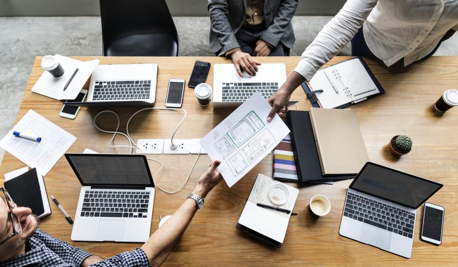 Business professionals working at an office desk with reports and computers