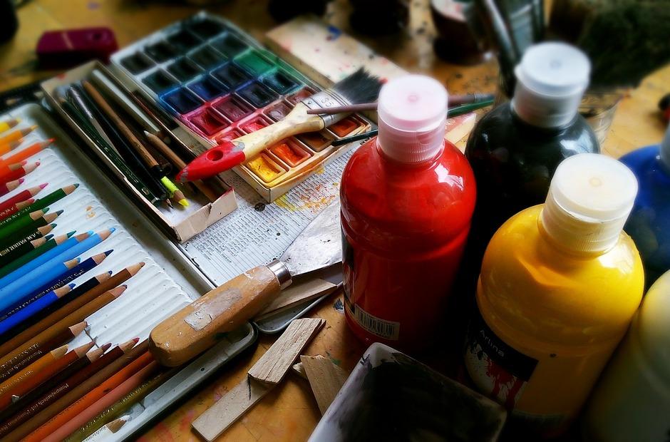 Colored pencils and paint on a table.