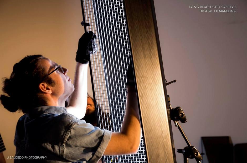 A film student setting up lighting for a scene.
