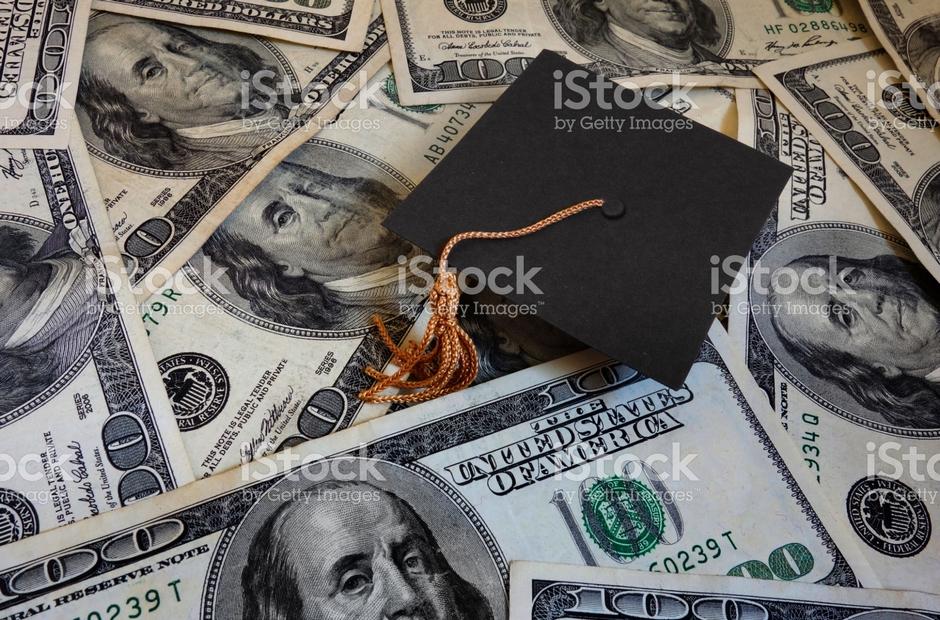 A graduation cap sitting on a pile of money.