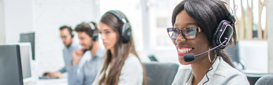 Smiling young woman with headset working in call center