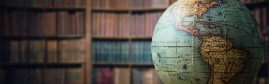 Old globe on bookshelf background. Selective focus. Retro style. Science, education, travel, vintage background.