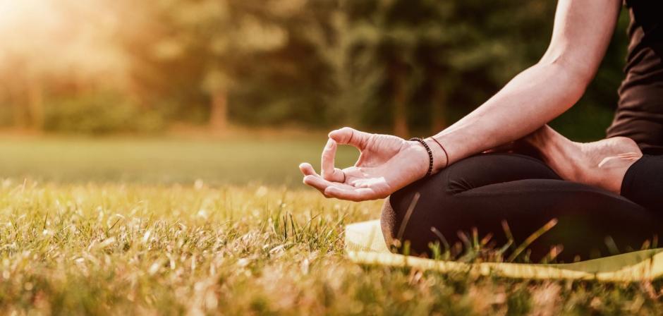 Close up of young woman practicing yoga in the back yard with copy space
