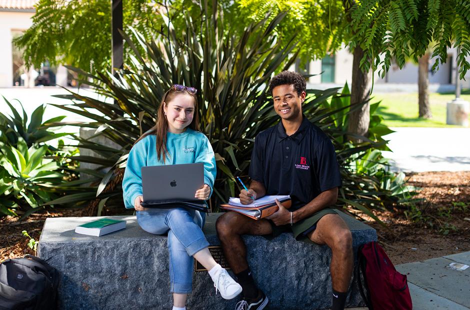 LBCC new and continuing students smiling and working together with laptop  and textbooks