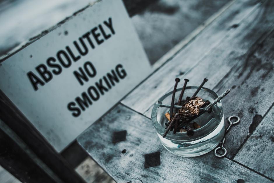 An ashtray next to a no smoking sign.