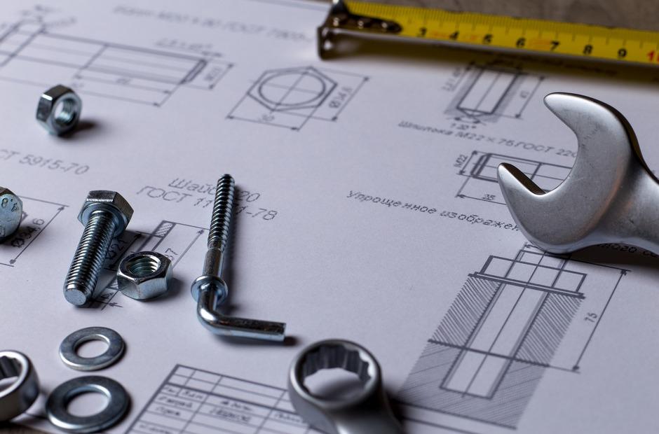 A schematic with nuts and bolts on laying on top.