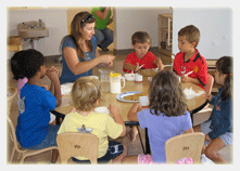 Teachers teaching a group of children with teaching materials