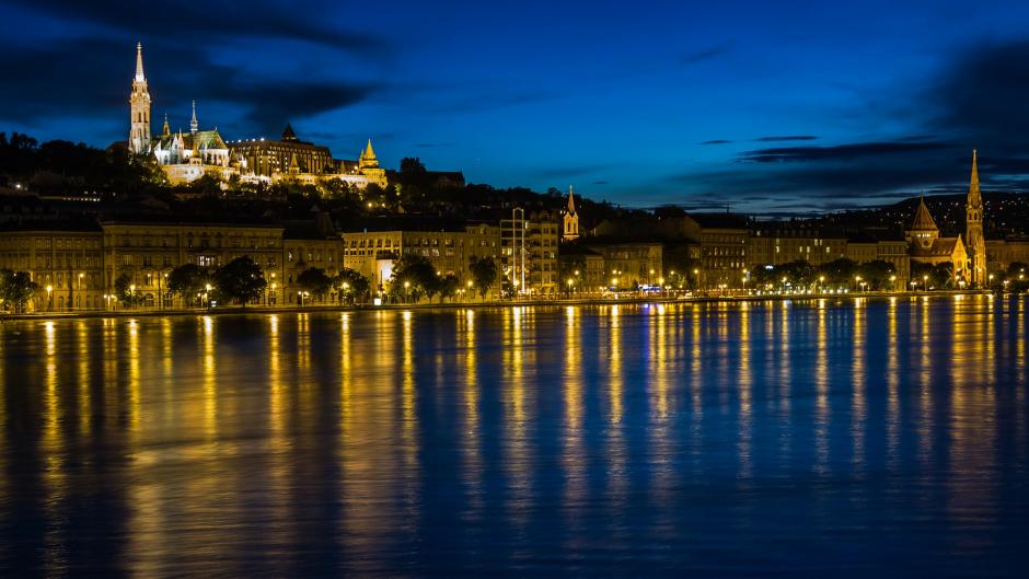 The city of Budapest at night on the Danube River.