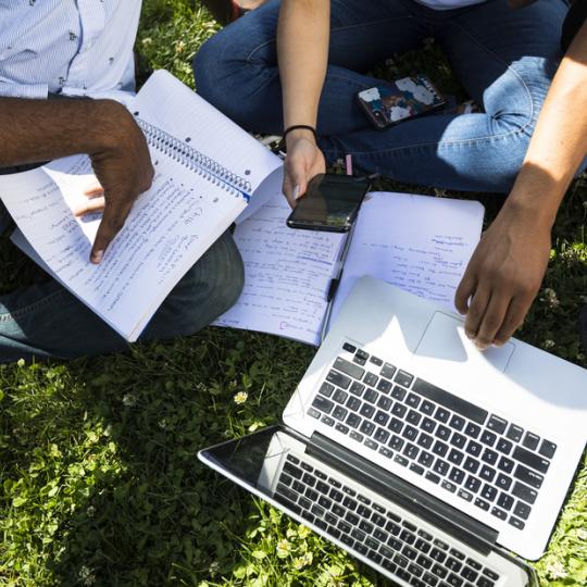 Students around a laptop and studying.