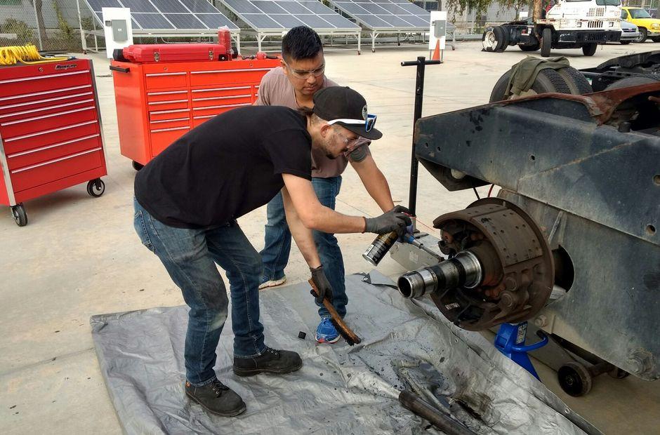 Two LBCC students repairing an alternative fuel vehicle.
