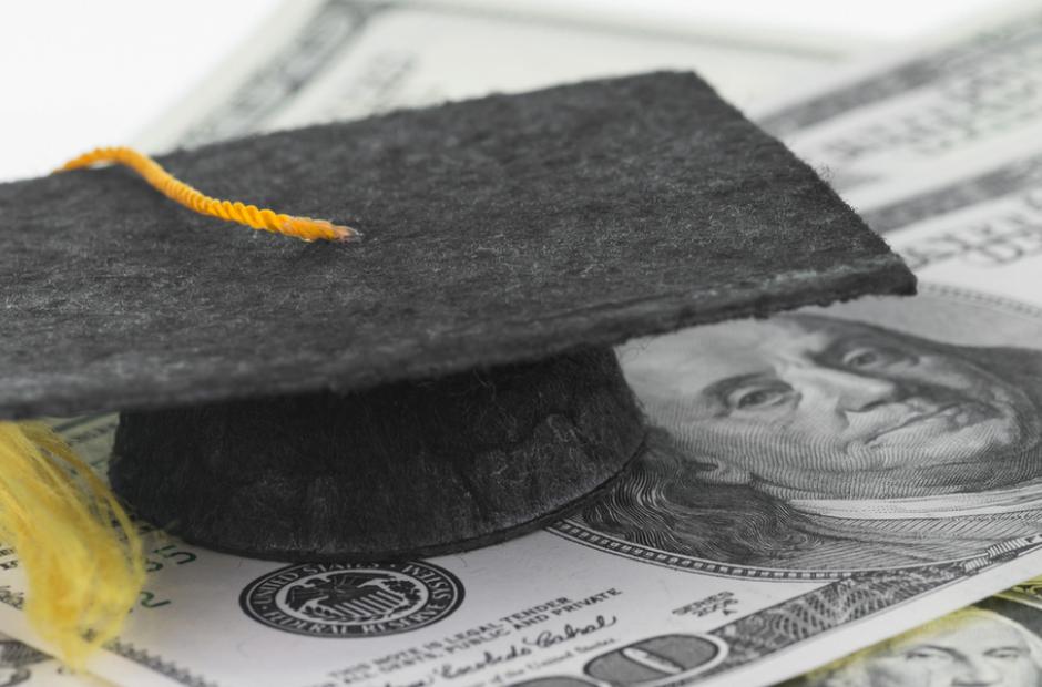 A graduation cap surrounded by money.
