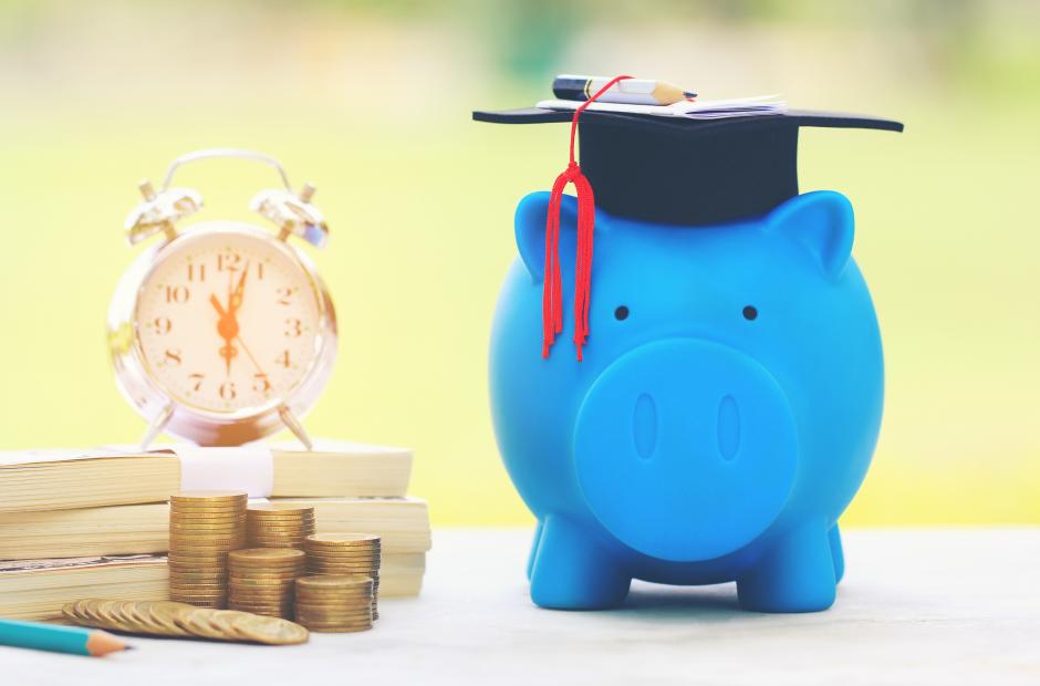 Graduation hat on blue piggy bank with stack of coins money and banknote on natural green background, Saving money for education concept