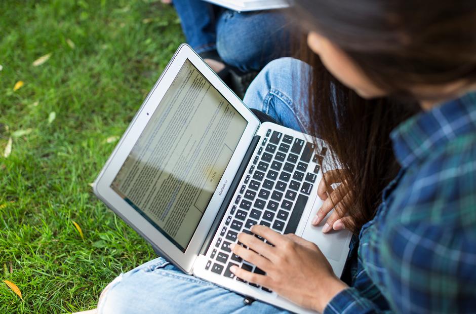 A student Accessing Enrollment Guides & Resources from a laptop computer