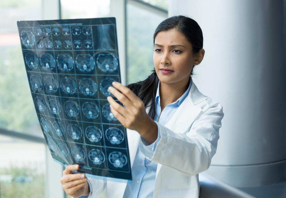 A doctor looking at a set of x-rays.