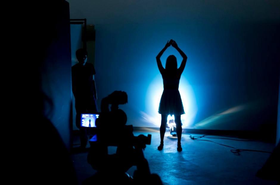 A student film being shot in dark room with blue light.