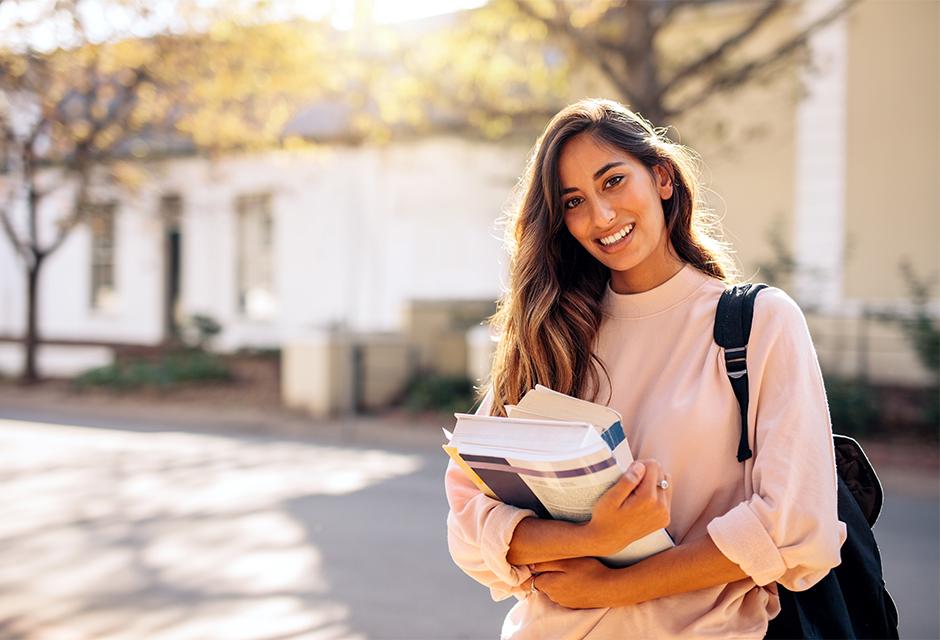 Female college student with books outdoors