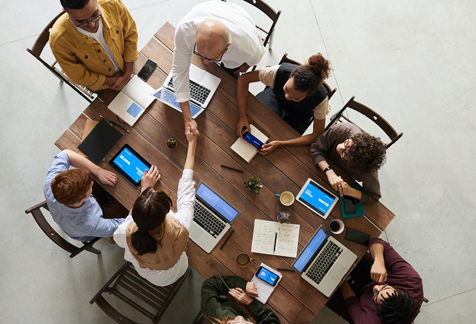 A group of business people meeting at the table with computer technology. Business concept