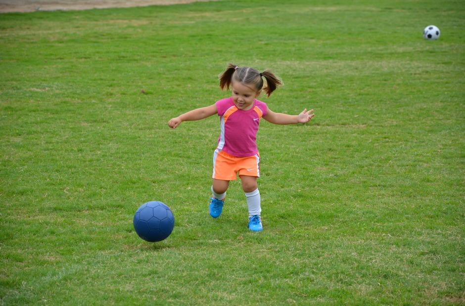 A young girl playing with a ball.