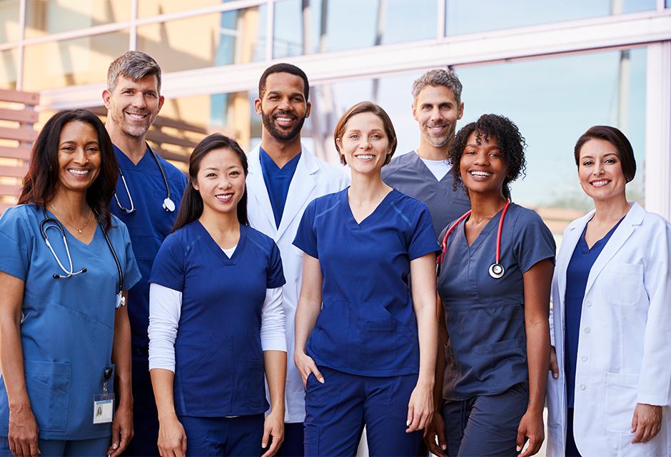 Smiling medical team standing together outside a hospital 