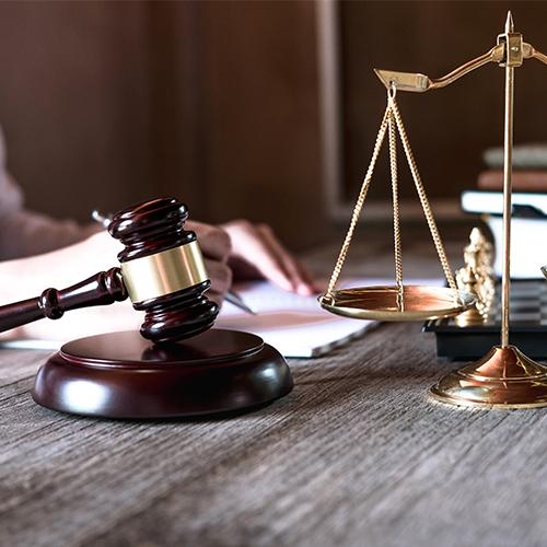 Lawyers working with brass scale on wooden desk in office at background. Law, legal services, advice, Justice concept. 