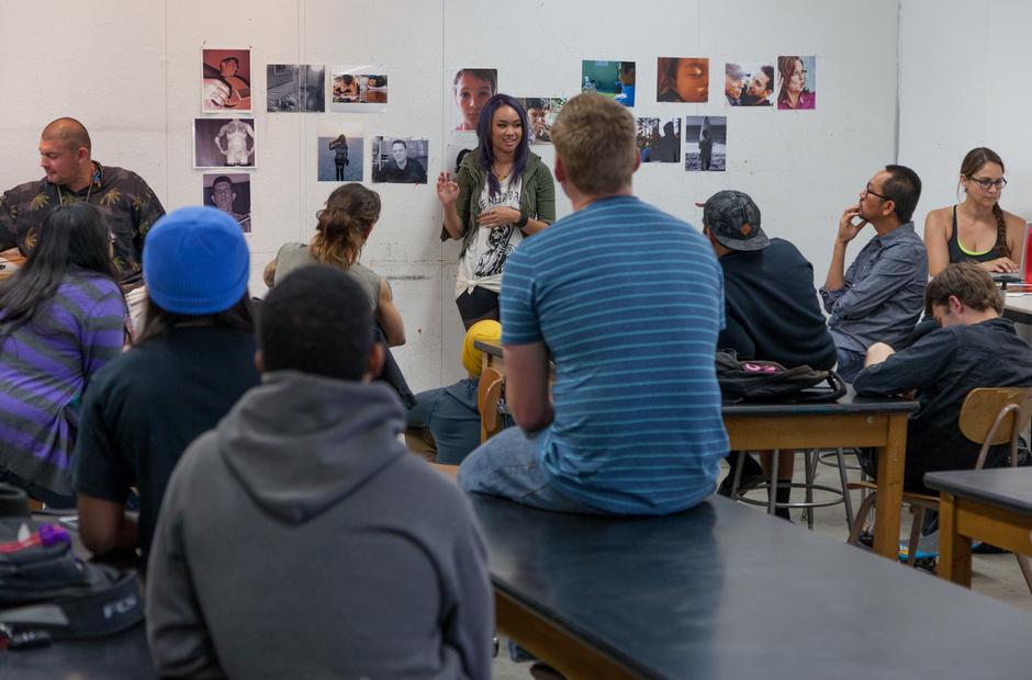 A group of students reviewing photographs on display.