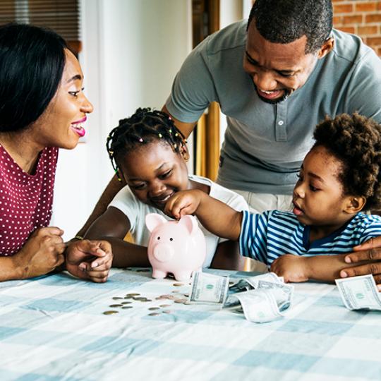 Family saving money to piggy bank