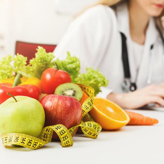 Nutritionist desk with fruit and measuring tape