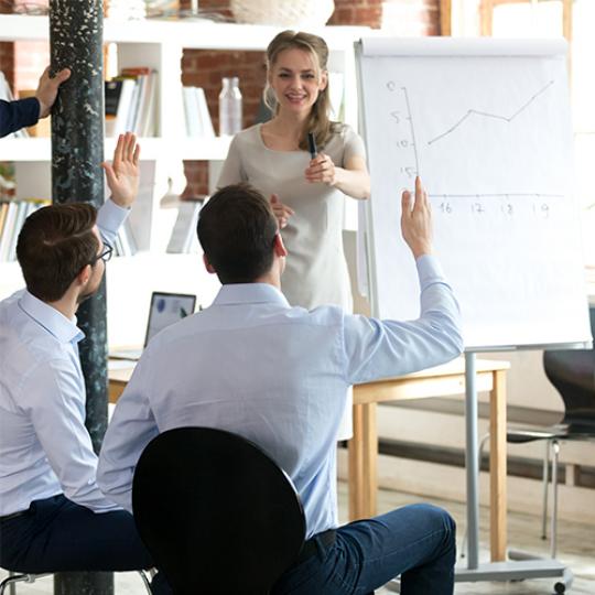 female mentor invite employee present idea on flipchart