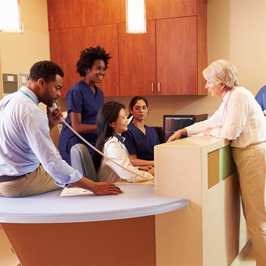 Medical Staff At Busy Nurse's Station In Hospital